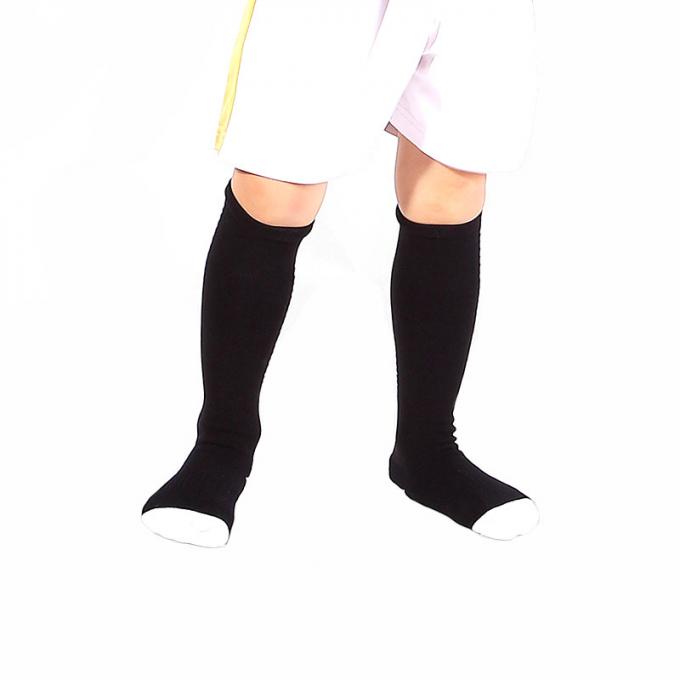 Lange Socken der Kinderstrümpfe verdickten den unteren Fußball des Tuches, der nicht- Belegsport auf Lager, den Strümpfe Sportsocken der Kinder tragen